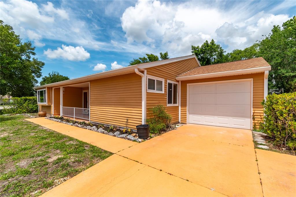 A single-story house with yellow siding, a front porch, and an attached one-car garage — 10886 SW 90TH TERRACE, OCALA, FL