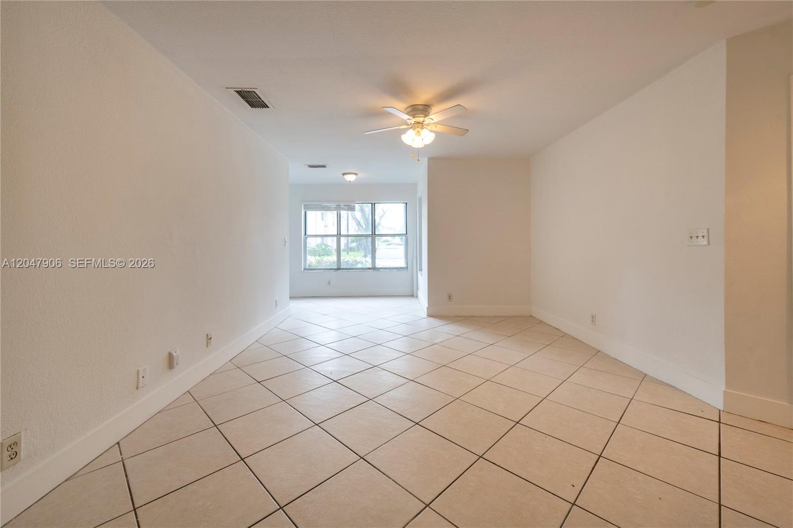 An empty room features white walls, light-colored tile flooring, and a ceiling fan — 3480 N Pinewalk Dr N # 116, Margate FL 33063, MARGATE, FL