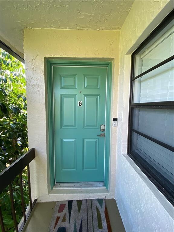 A teal front door with the letter G sits on a covered exterior porch — 21766 Cypress Drive # g, Boca Raton FL 33433, BOCA RATON, FL