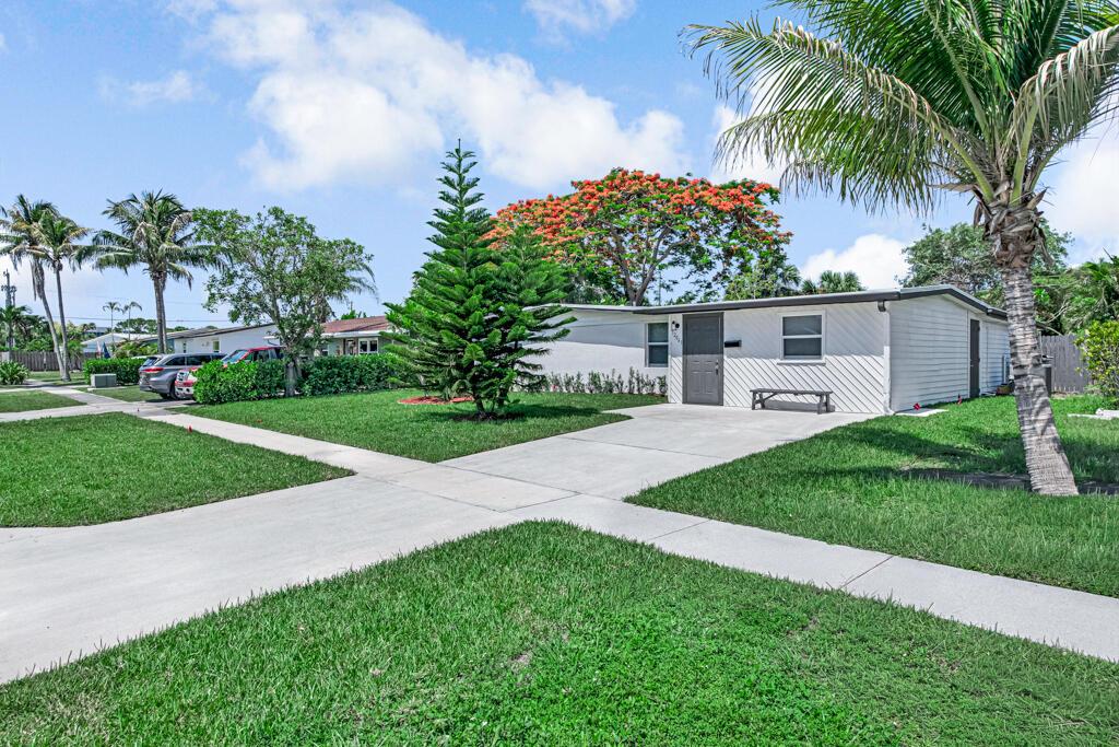 A white single-story house with a driveway, a pine tree, and a palm tree — 12063 Acapulco Avenue, Palm Beach Gardens FL 33410, PALM BEACH GARDENS, FL
