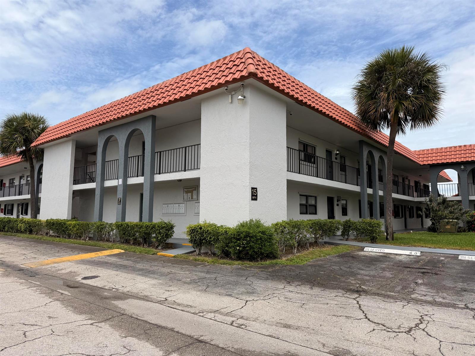 A two-story apartment building with white stucco walls, a red tile roof, and arched accents — 2021 W Woolbright Road # G205, Boynton Beach FL 33426, BOYNTON BEACH, FL