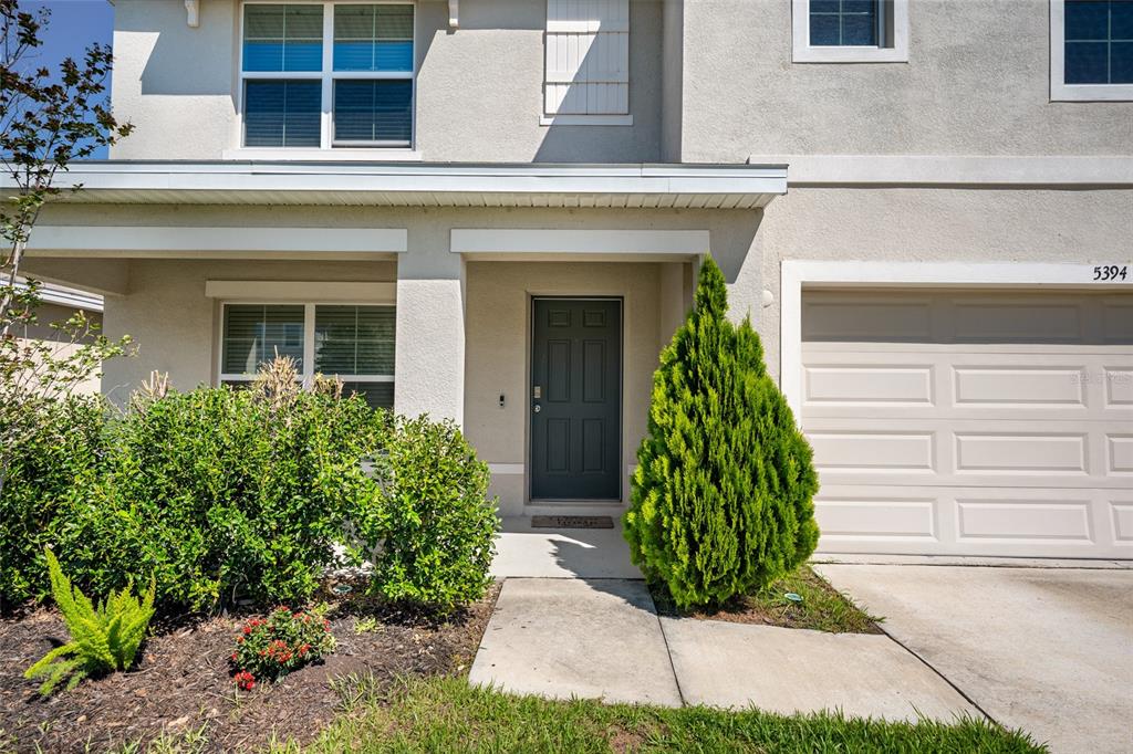 The exterior of a two-story house features a front door, garage, and landscaping — 5394 SW 40TH CIRCLE, OCALA, FL