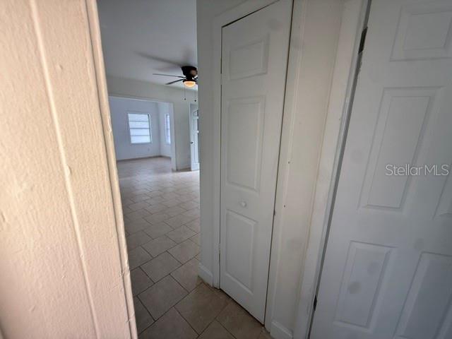 An empty room with white walls, tile flooring, a ceiling fan, and a built-in shelf — 8766 PORTO BELLO AVENUE, NORTH PORT, FL