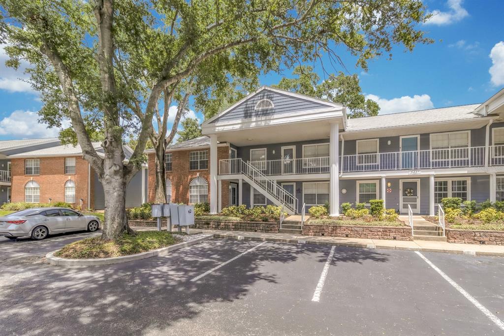 A two-story apartment building with a covered entrance, white columns, and a parking lot — 5417 LAKE MARGARET DRIVE UNIT F, ORLANDO, FL