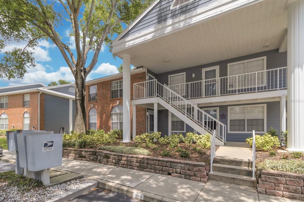 A two-story apartment building features a brick and gray siding exterior with an outdoor staircase — 5417 LAKE MARGARET DRIVE UNIT F, ORLANDO, FL