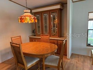 A dining room features a wooden table, four chairs, a hutch, and a hanging lamp — 2532 AMYRIS COURT UNIT 601, ZELLWOOD, FL