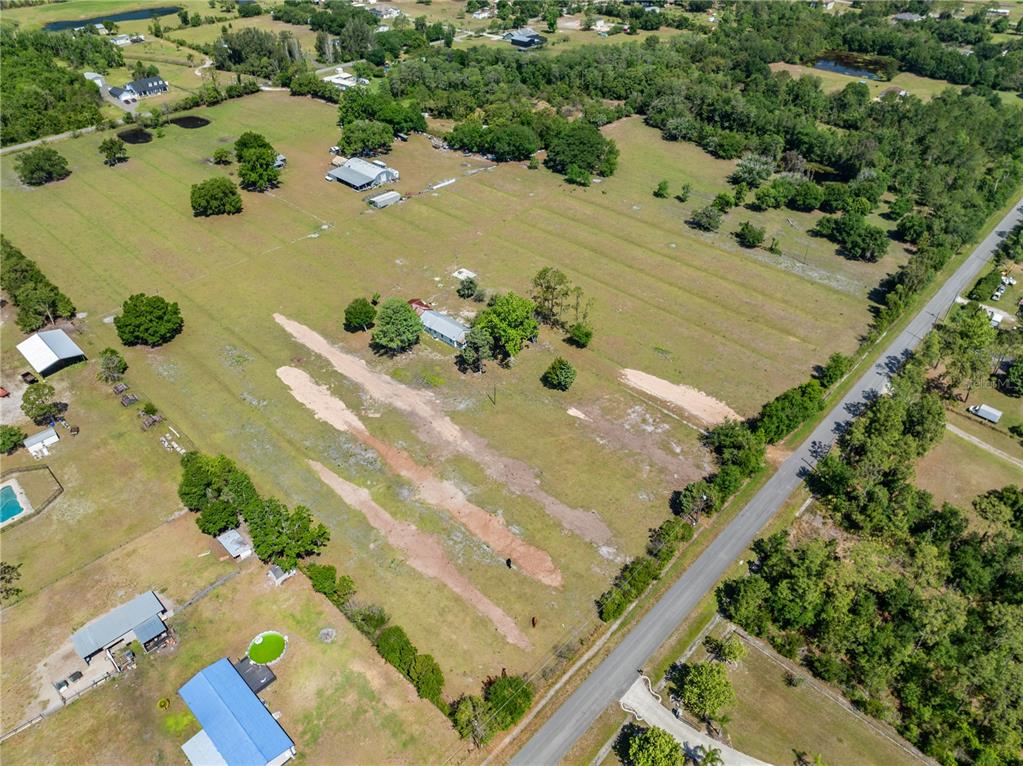 An aerial view shows a rural property with a house, outbuildings, and open pasture land — 3954 LA SALLE AVENUE, ST CLOUD, FL
