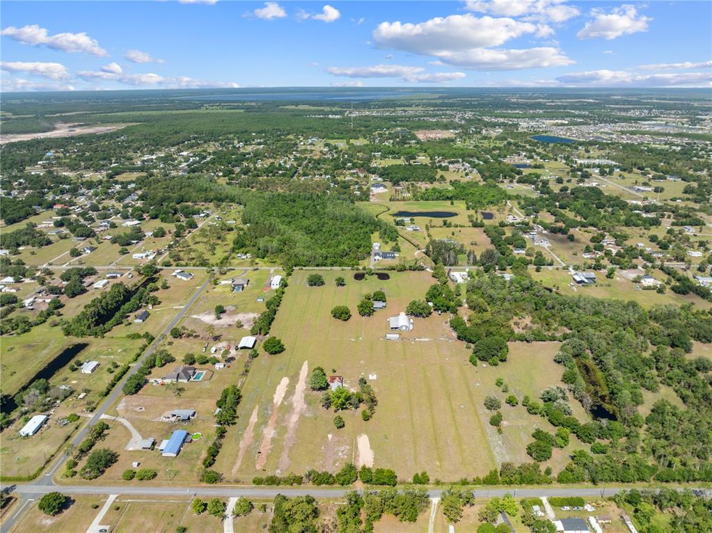 An aerial view shows a large, grassy rural property with several buildings and scattered trees — 3954 LA SALLE AVENUE, ST CLOUD, FL