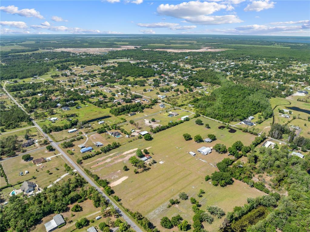 An aerial view shows a rural residential area with scattered houses, pastures, and wooded lots — 3954 LA SALLE AVENUE, ST CLOUD, FL