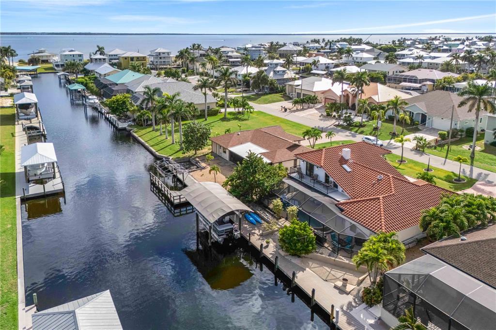An aerial view of a waterfront house with a boat lift and canal access — 2420 CHERIMOYA LANE, ST JAMES CITY, FL