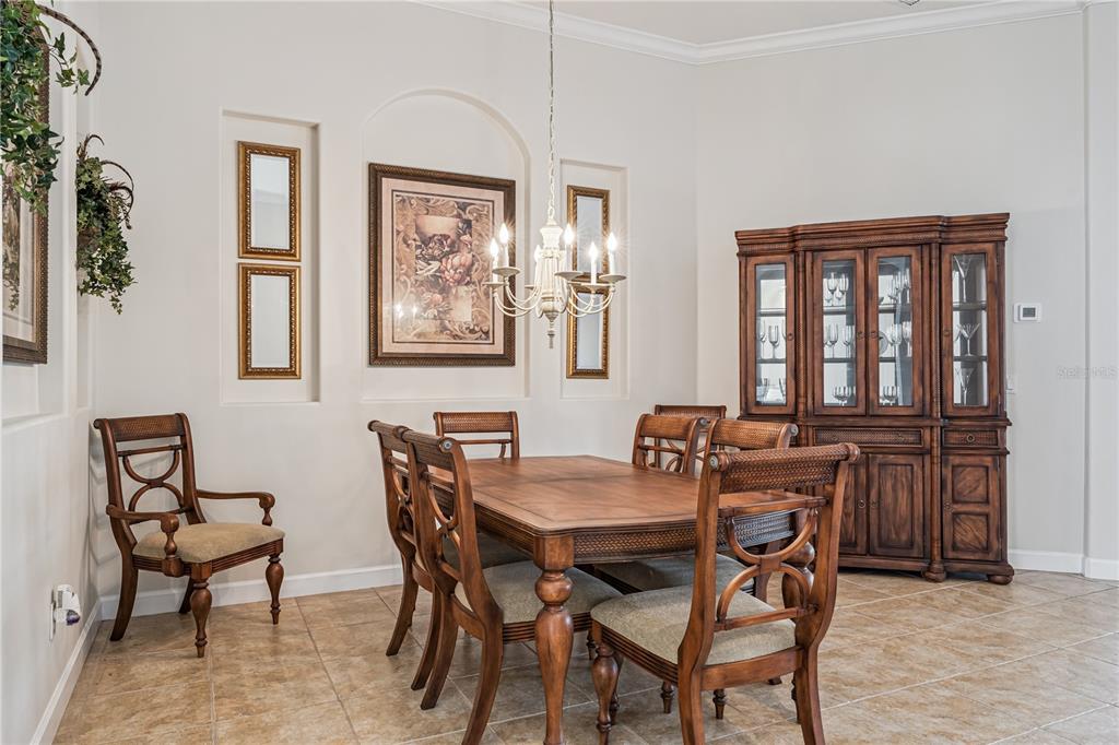 A dining room features a wooden table, matching chairs, a china cabinet, and wall niches — 1949 DEERVIEW PLACE, LONGWOOD, FL