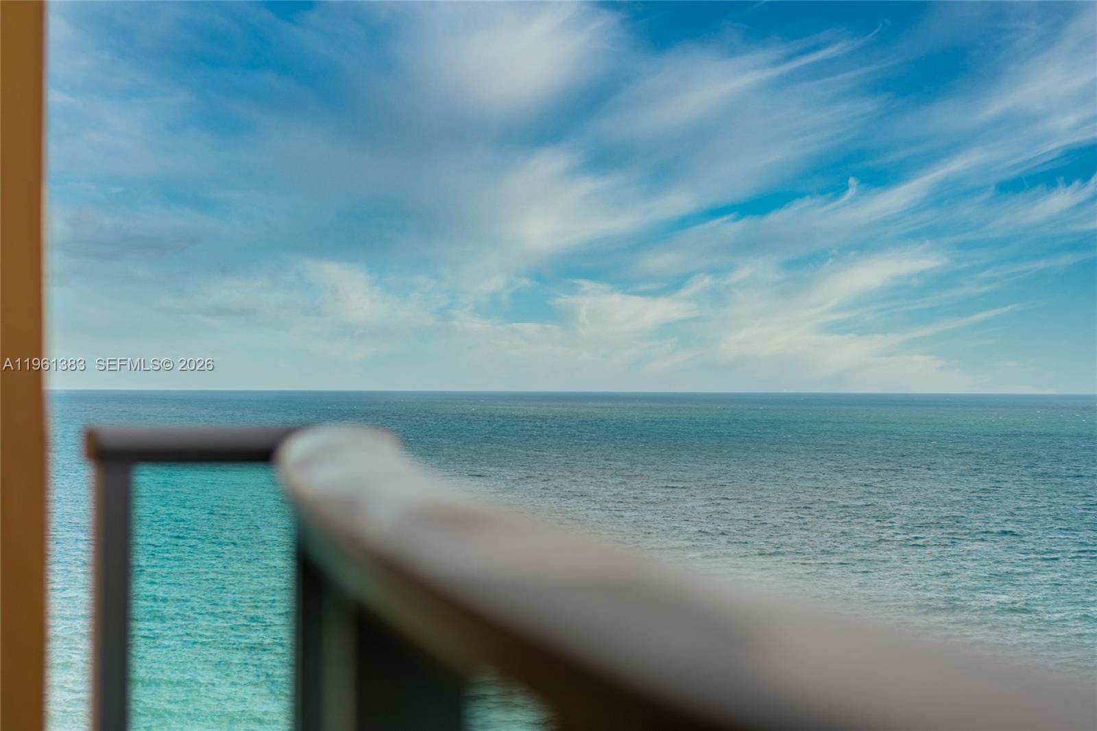 A view of the ocean and sky from a balcony with a glass railing — 2501 S Ocean Dr # 1617, Hollywood FL 33019, HOLLYWOOD, FL