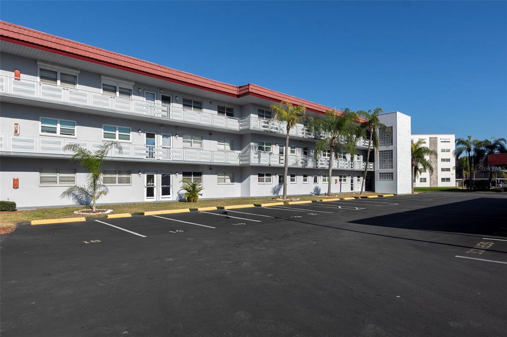 A three-story apartment building with a flat roof and a paved parking lot in front — 5660 80TH STREET N UNIT A202, ST PETERSBURG, FL