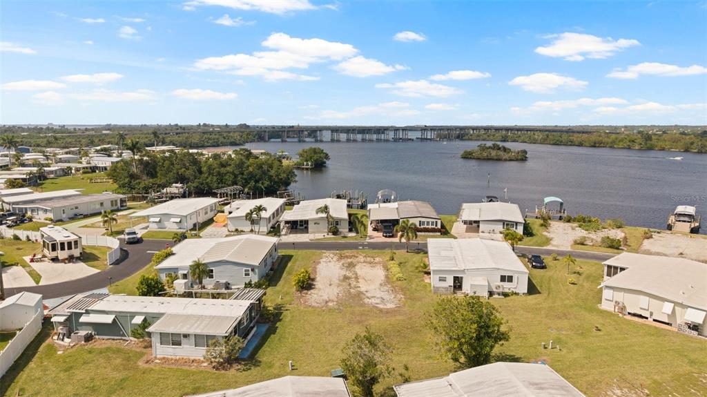 An aerial view of a waterfront mobile home community with a vacant lot in the foreground — 362 SHORELAND DRIVE, FORT MYERS, FL