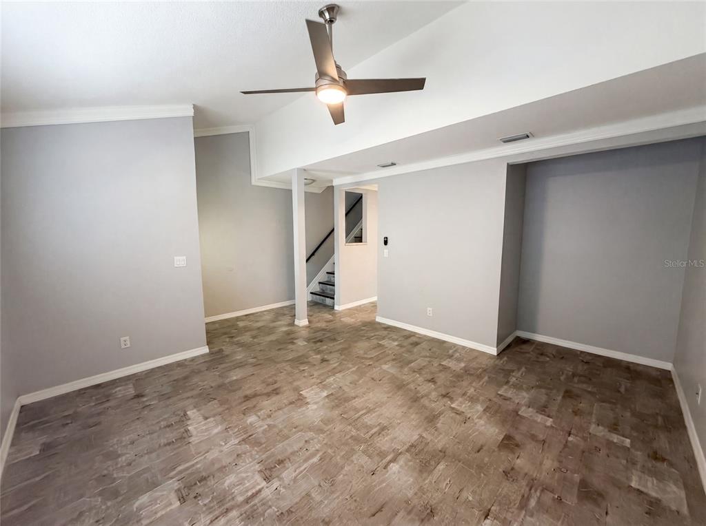 An empty room with gray walls, wood-look flooring, a ceiling fan, and a staircase — 2308 S PARK AVENUE, SANFORD, FL