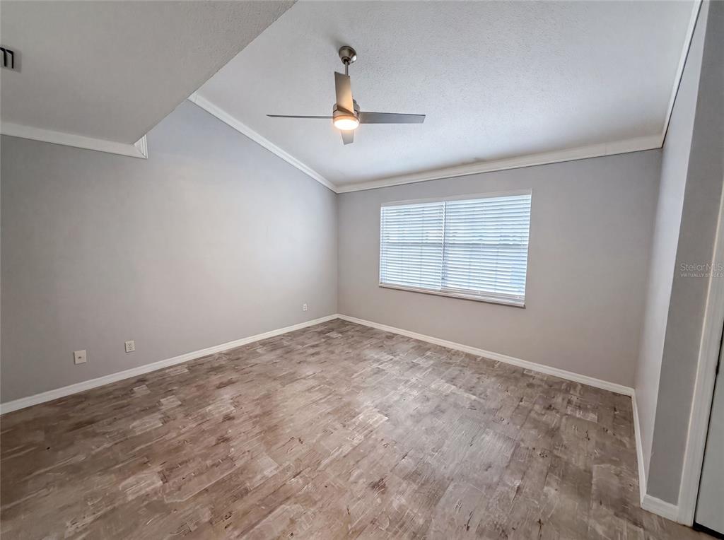 An empty room with light gray walls, wood-look flooring, and a ceiling fan — 2308 S PARK AVENUE, SANFORD, FL