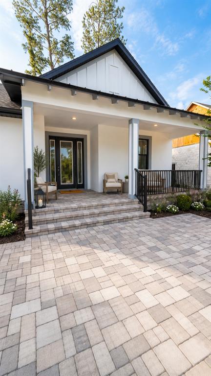A modern house exterior features a covered front porch with stone steps and paver patio — 6757 SUMMIT VIEW DRIVE, BROOKSVILLE, FL