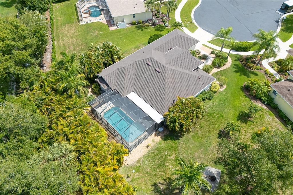An aerial view shows a house with a screened-in pool and a shingled roof — 122 CLEAR LAKE DRIVE, ENGLEWOOD, FL