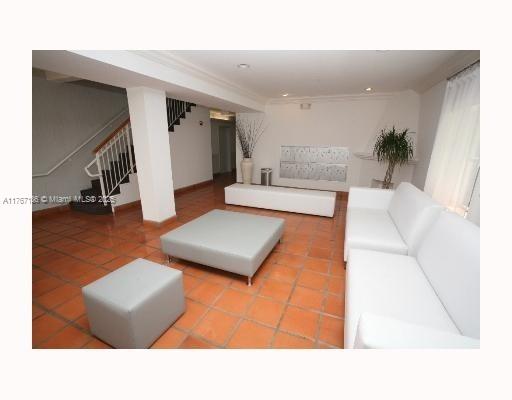 A lobby area features white sofas, a gray ottoman, and terracotta tile flooring — 1521 Lenox Ave # 101, Miami Beach FL 33139, MIAMI BEACH, FL