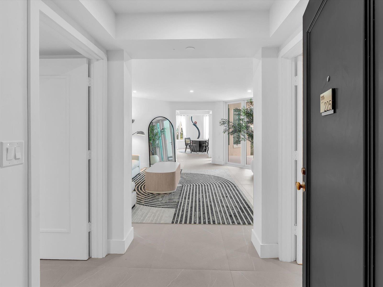 A view from a doorway into a bright apartment with a modern patterned area rug — 120 SE 5th Avenue # 225, Boca Raton FL 33432, BOCA RATON, FL
