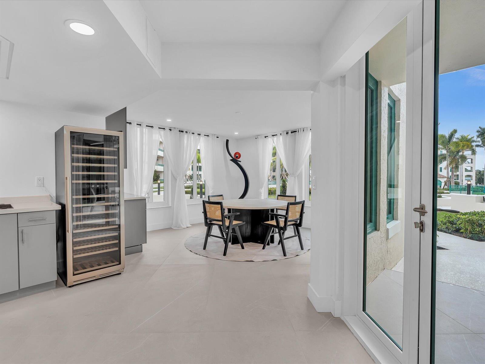 A dining area with a round table, cane chairs, and a wine cooler in a room — 120 SE 5th Avenue # 225, Boca Raton FL 33432, BOCA RATON, FL
