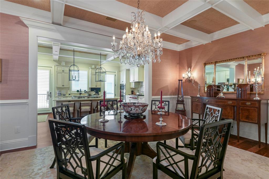 A formal dining room features a round wooden table, chandelier, and pink textured wallpaper — 413 W MORSE BOULEVARD, WINTER PARK, FL