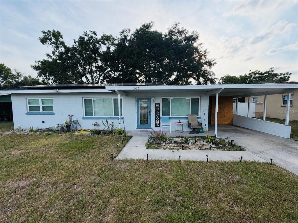 A single-story house with a light blue exterior, a front carport, and a concrete walkway — 105 MARGARET STREET, AUBURNDALE, FL