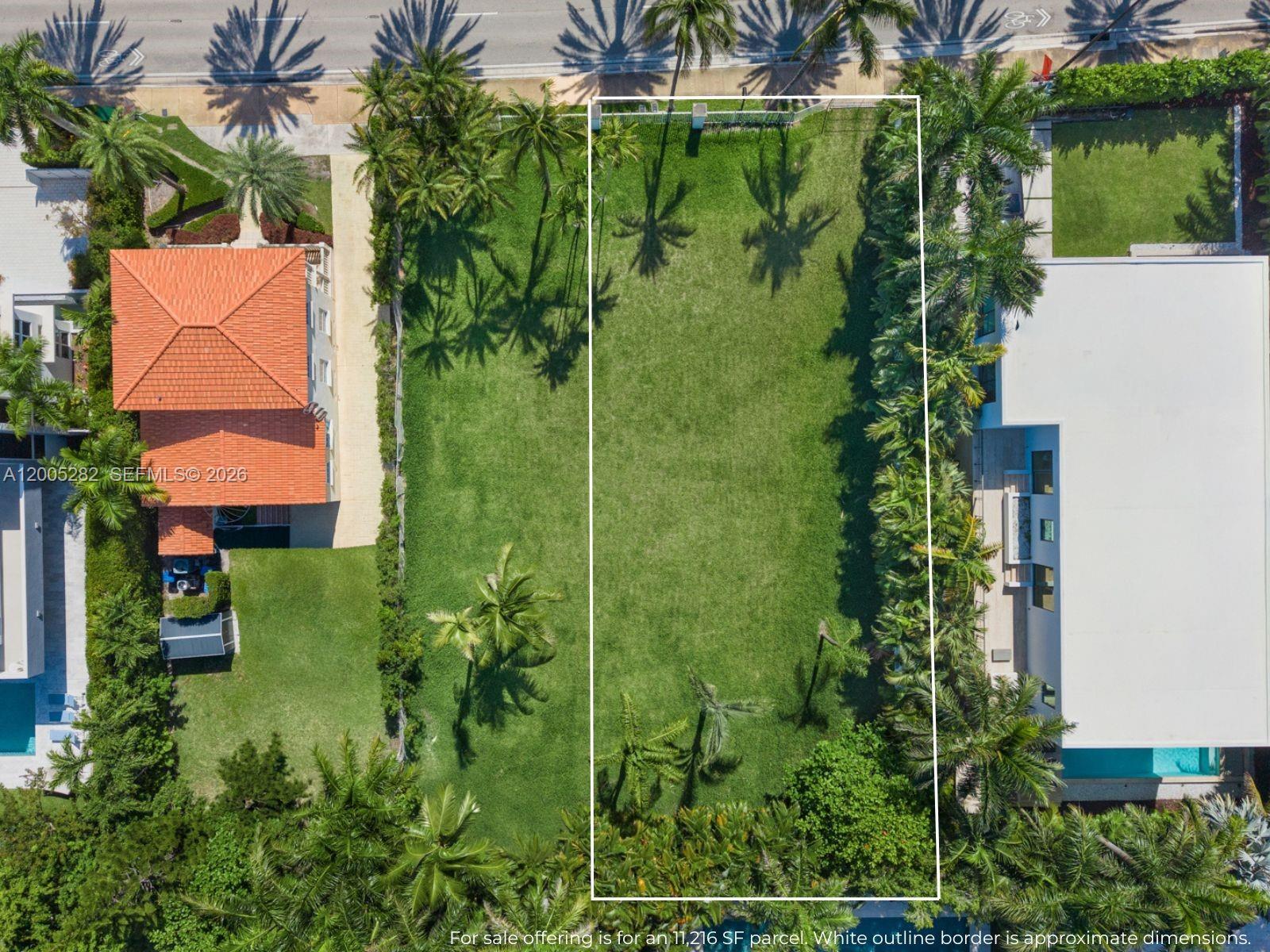 An aerial view shows a vacant rectangular lot bordered by palm trees and neighboring houses — 254 Ocean Blvd, Golden Beach FL 33160, GOLDEN BEACH, FL