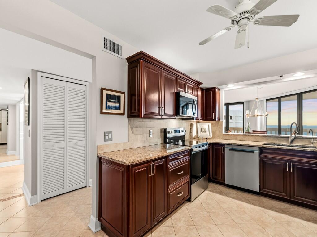 A living room with a sofa, armchairs, a desk, and floor-to-ceiling windows overlooking the ocean — 9960 S Ocean Drive # 1905, Jensen Beach FL 34957, JENSEN BEACH, FL