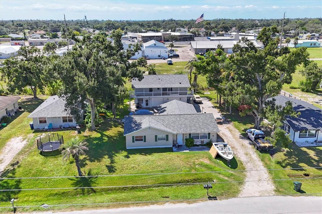 An aerial view shows a residential property with a house, a detached garage, and trees — 2210,2212,2214 PARK ROAD, VENICE, FL