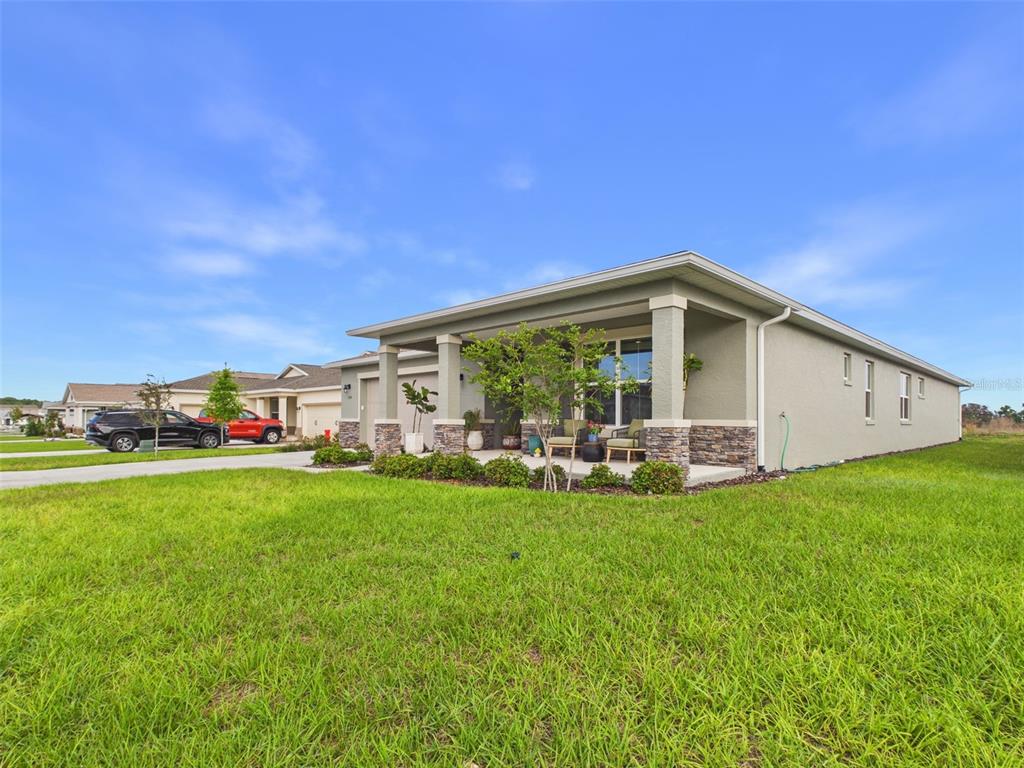 A single-story house with a covered front porch, stone accents, and a large grassy lawn — 7545 SW 56TH PLACE, OCALA, FL