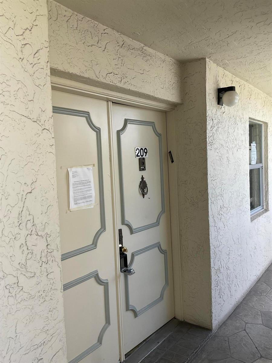 A white double door with a number 209 sign and a door knocker — 6768 N 10th Ave N # 209, Lake Worth FL 33467, LAKE WORTH, FL