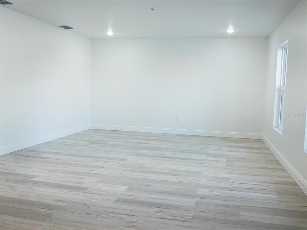 A living room with a large sectional sofa, coffee tables, and an adjacent open-concept kitchen — 2201 CONWAY DRIVE UNIT 201, DELTONA, FL