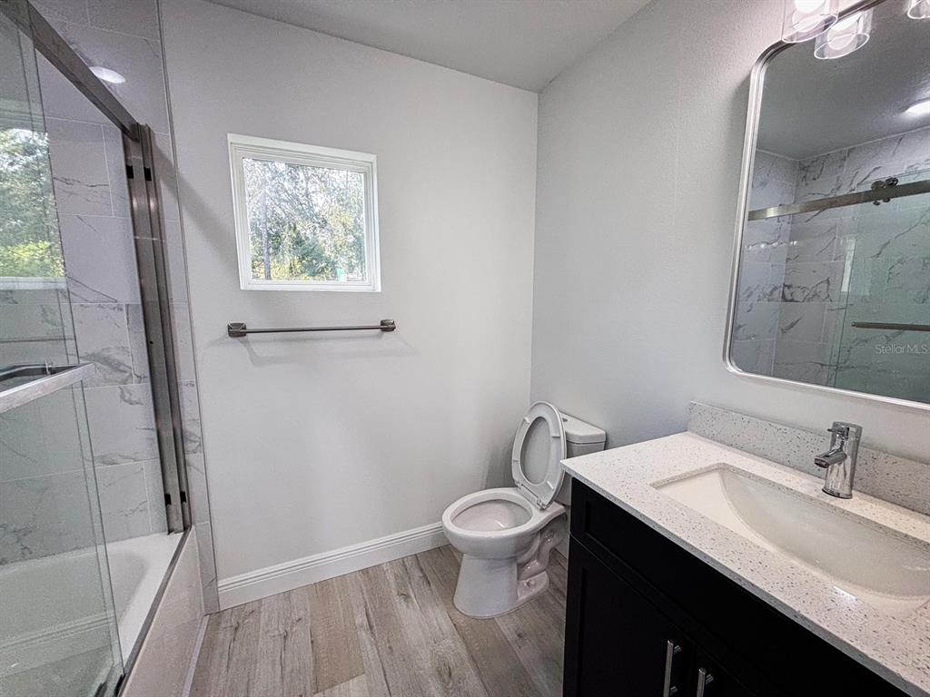 A kitchen features dark cabinets, stainless steel appliances, and a small dining table with chairs — 2201 CONWAY DRIVE UNIT 201, DELTONA, FL