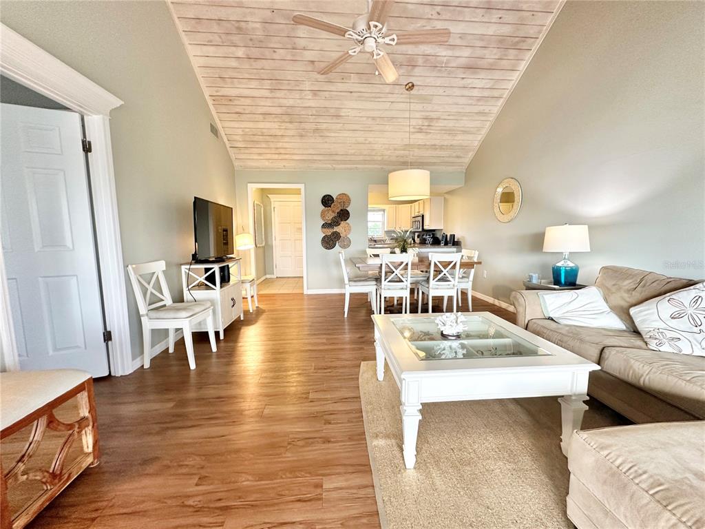 A living room and dining area feature wood-plank ceilings, light flooring, and neutral furniture — 1096 VILLA LANE UNIT 78, APOPKA, FL