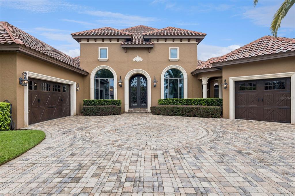 A foyer features a stone console table, an arched iron door, and a dining area — 25608 GRANDVIEW POINTE, SORRENTO, FL