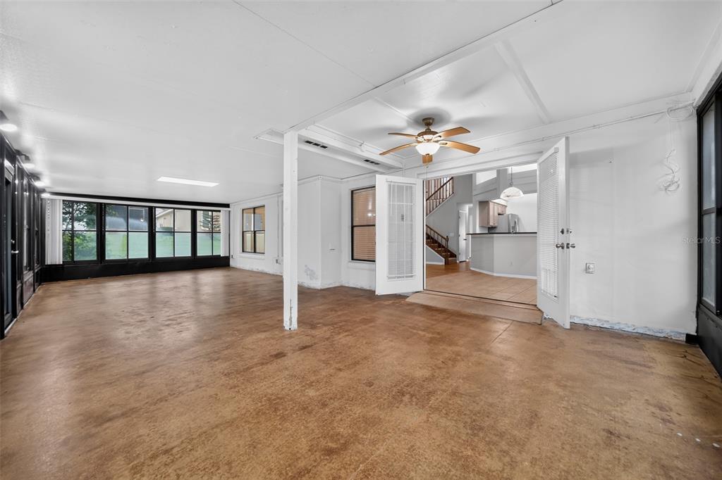 A sunroom with concrete floors, a ceiling fan, and double doors leading to a kitchen — 1375 AUGUSTA NATIONAL BOULEVARD, WINTER SPRINGS, FL