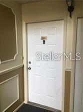 A white six-panel door with a house number is situated in a beige hallway — 3984 VERSAILLES DRIVE UNIT 3984C, ORLANDO, FL