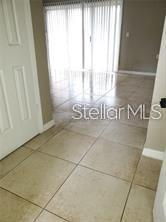 A tiled entryway leads toward a room with vertical blinds covering a sliding glass door — 3984 VERSAILLES DRIVE UNIT 3984C, ORLANDO, FL