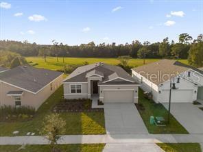 An aerial view shows a suburban single-story house with a two-car garage and driveway — 4385 PEBBLES THROW DRIVE UNIT B, KISSIMMEE, FL