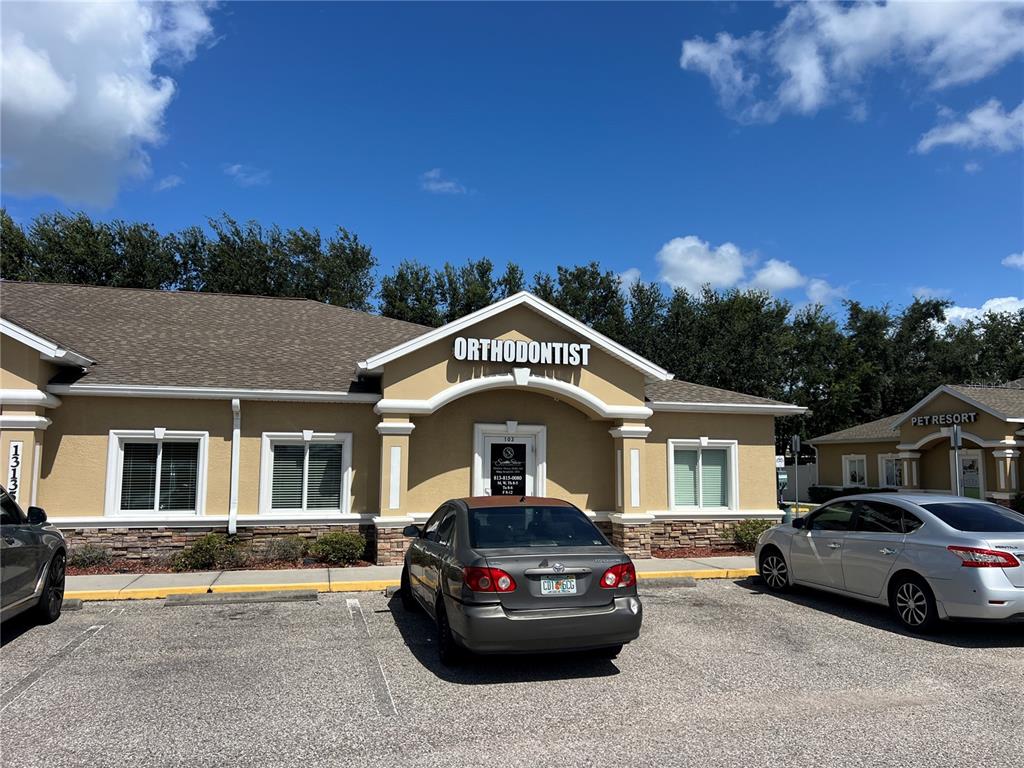 A single-story commercial building with a stone base and a parking lot in front — 13135 KINGS LAKE DRIVE UNIT 103, GIBSONTON, FL