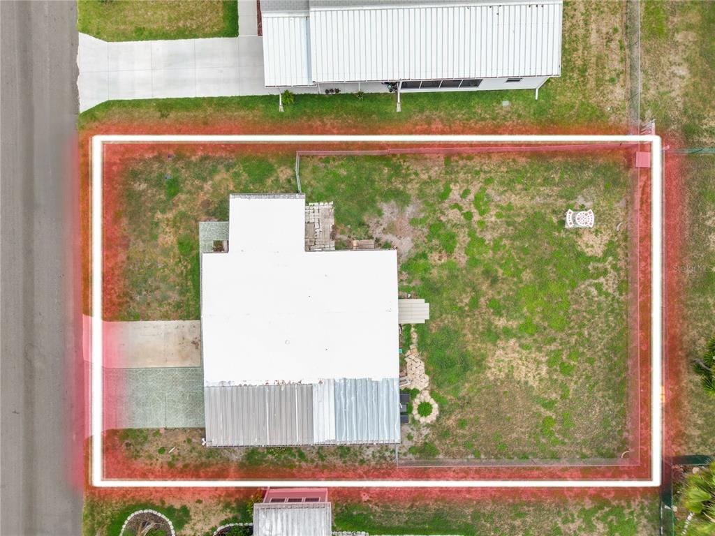 An aerial view shows a house with a white roof on a fenced rectangular lot — 1610 REYNOLDS ROAD UNIT 330, LAKELAND, FL