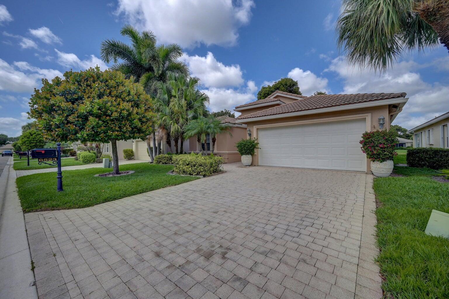 A single-story house with a paved driveway, a two-car garage, and a landscaped front yard — 6523 Via Trento, Delray Beach FL 33446, DELRAY BEACH, FL