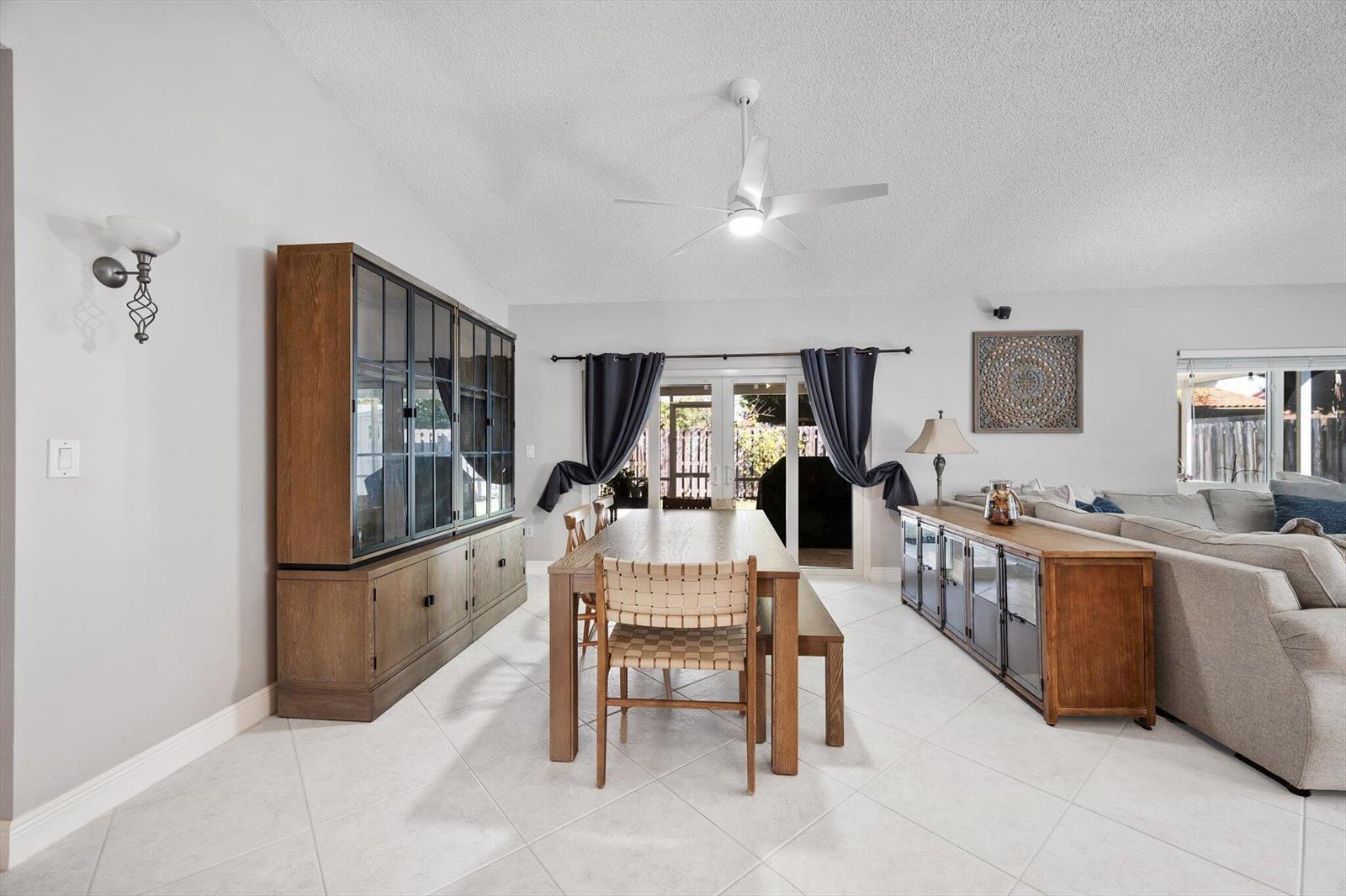 A dining room with a wooden table, woven chairs, and a large glass-fronted cabinet — 15541 Dover Court, Davie FL 33331, DAVIE, FL