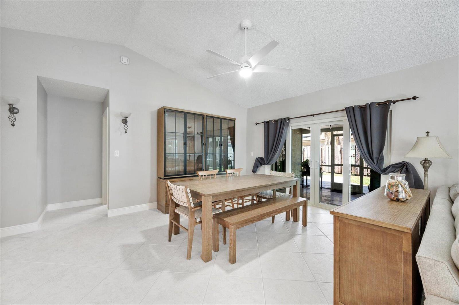 A dining room features a wooden table, bench, chairs, hutch, and sliding glass patio doors — 15541 Dover Court, Davie FL 33331, DAVIE, FL