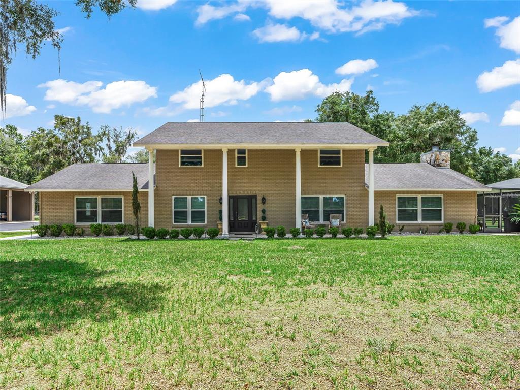 A two-story brick house with a central porch and a large front lawn — 12941 SW 8TH AVENUE, OCALA, FL