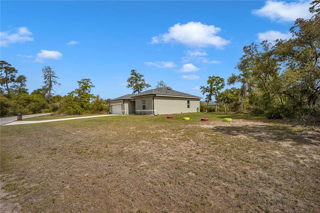 A single-story house with a garage and driveway sits on a large, grassy lot — 15841 SW 19TH TERRACE, OCALA, FL