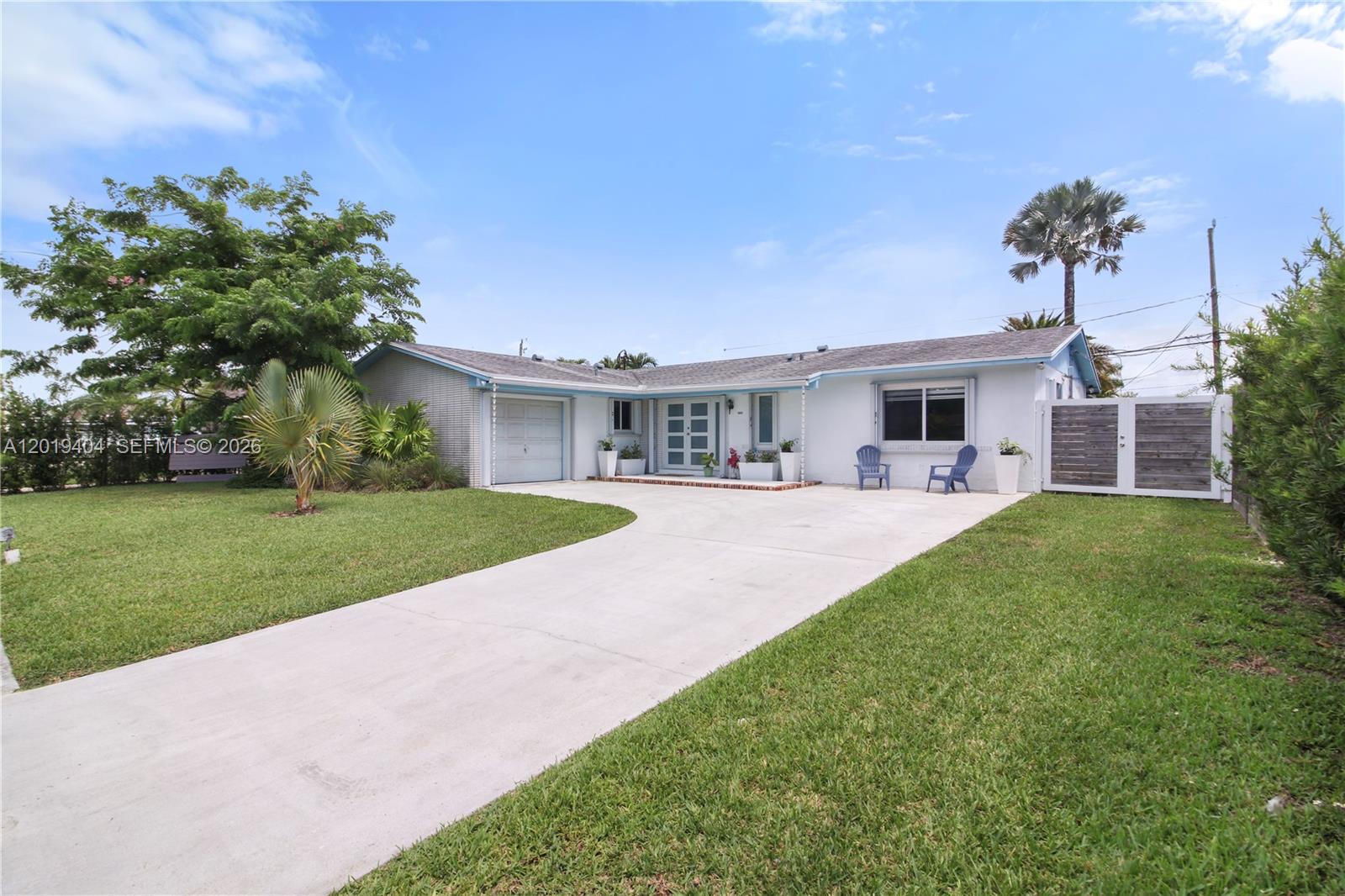 A single-story white house with a concrete driveway, a garage, and a front lawn — 10455 SW 200th St, Cutler Bay FL 33157, CUTLER BAY, FL