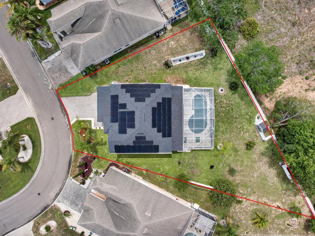 Aerial view of a house with solar panels and a screened pool on a lot — 2596 SAND HILL POINT CIRCLE, DAVENPORT, FL
