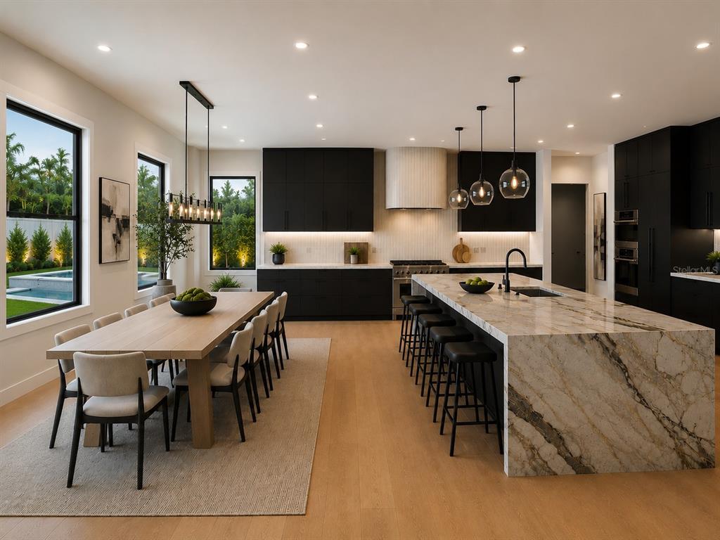 A modern kitchen and dining area features black cabinetry, a marble island, and light wood floors — 1011 S MORRISON COURT, TAMPA, FL